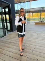 Chaleco negro de cuero con detalle de tachas en el contorno.