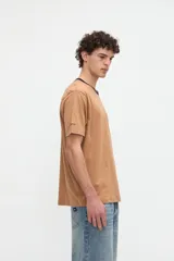 Remera blanca de algodón con textura suave, corte relaxed, manga corta, cuello redondo en contraste de color celeste y un bolsillo aplicado en el pecho.