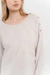 Remera manga larga color rosa con bolsillo en el pecho y corte irregular en el ruedo.