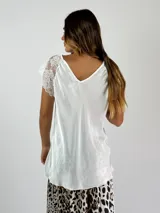 Blusa blanca de viscosa con escote en V y mangas cortas de encaje floral.