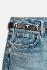 Jeans de tiro alto color azul claro, con cinco bolsillos y pernera recta que se estrecha hacia el tobillo. Incluye un cinturón negro con detalles metálicos. Cierre frontal con cremallera y botón.