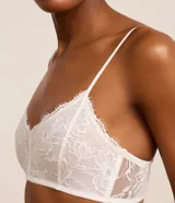 Soutien top de encaje floral color blanco, sin copa y sin aro, con tirantes ajustables y ribetes delicados en los bordes.