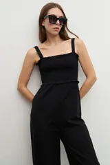 Mono negro de corte palazzo, con breteles finos y escote recto con detalle de smock.