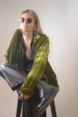 Campera verde aceituna de terciopelo con cierre frontal, cuello alto y puños elásticos.