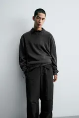 Jersey de corte relajado confeccionado en hilatura de algodón con efecto lavado. Presenta cuello redondo, manga larga y acabados en rib en cuello, puños y bajo.