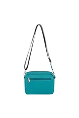 Bandolera negra con textura granulada, cierre superior y bolsillo frontal con cierre. Incluye correa ajustable con logo de la marca y un charm colgante de cuerdas multicolor.