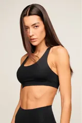 Top deportivo blanco de poliamida con diseño de espalda nadador, breteles medios y banda elástica inferior para mayor soporte. Cuenta con forro interno y entrada para copas removibles.