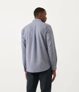 Camisa de manga larga color celeste con textura, cuello camisero, cierre frontal con botones y dos bolsillos de parche en el pecho.