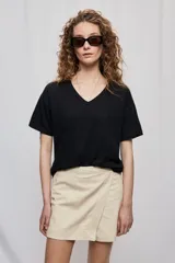 Short cruzado de tiro medio con diseño frontal tipo falda, color negro, de líneas simples y calce cómodo.