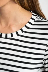 Remera de manga larga con diseño de rayas horizontales en blanco y negro, cuello redondo y corte ajustado al cuerpo.