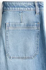 Jean de denim celeste de tiro alto con piernas amplias, corte holgado y bolsillos frontales tipo parche.