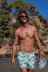 Short de baño con estampado botánico y geométrico en tonos celestes, verdes y blancos. Cuenta con cintura elástica con cordón ajustable, dos bolsillos laterales y un bolsillo trasero.