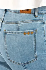 Jean de corte recto y tiro medio, confeccionado en denim de algodón con un toque de elastano. Presenta costuras verticales decorativas a lo largo de las piernas y un ruedo deshilachado.