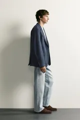 Blazer regular fit azul marino confeccionado en tejido con elasticidad, con cuello de solapas de muesca, cierre frontal con botones y bolsillos con solapa en la cadera.
