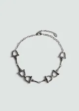 Collar plateado con cadena de eslabones y dijes con forma de espuelas.