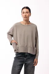 Remera de silueta amplia con hombro caído y cuello redondo, confeccionada en tejido suave de algodón. Presenta un diseño holgado y versátil con mangas largas.