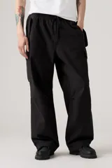 Pantalón cargo negro de corte holgado, con cintura elástica y cordón ajustable. Presenta bolsillos laterales y bolsillos cargo con solapa en los muslos.