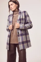 Blazer gris con estampado de cuadros en azul y marrón, solapas de muesca, cierre con un botón y bolsillos con solapa.