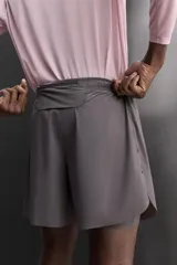 Pantalones cortos de running confeccionados en tejido técnico ligero y elástico, con malla interior. Presentan cintura elástica ajustable con cordón, bolsillo trasero con cierre y aberturas laterales en el bajo.