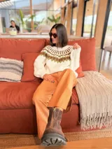 Sweater tejido a mano en mohair, de color marrón con diseño de canesú estampado con corazones fucsias y detalles geométricos en tonos beige y rosado. Presenta cuello redondo y mangas largas.