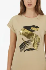 Remera de algodón blanca, de corte holgado, manga corta con vuelta y cuello redondo. Cuenta con un estampado frontal abstracto con trazos en tonos marrón y foil dorado.