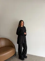 Conjunto oversize de dos piezas en tejido acanalado color beige, compuesto por una remera de manga larga con aberturas laterales y un pantalón largo de corte recto y holgado.