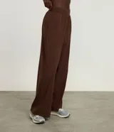 Pantalón deportivo de corte recto y holgado, color marrón, con cintura ancha elástica y pliegues frontales.