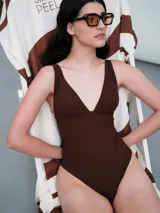 Malla de una pieza color marrón oscuro, con textura acanalada y escote profundo en V. Presenta tirantes anchos y copas removibles.