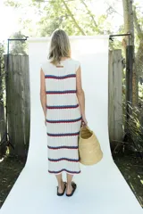 Vestido midi tejido en hilo de algodón, sin mangas y con escote redondo. Presenta un diseño de rayas horizontales en tonos beige, azul y rojo.