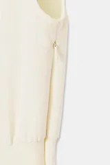 Vestido midi de crepe color blanco marfil, sin mangas, con cuello redondo y corte en la cintura. Falda con vuelo evasé y cierre lateral con cremallera oculta.