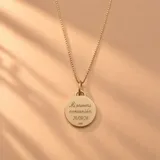 Collar de oro 18k con cadena de eslabones finos y dije redondo grabado con la inscripción 'Mi primera comunión' y fecha.