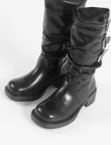 Botas negras de cuero sintético, con caña media, taco cuadrado y suela track. Presentan triple hebilla decorativa en la parte superior de la caña.
