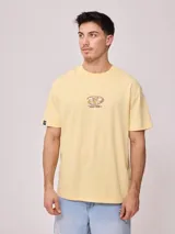 Remera color amarillo pastel de hombre, corte holgado, con estampado pequeño en el frente y estampado grande en la espalda. Confeccionada en algodón.