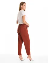 Pantalón de corte relajado con frente liso y cintura elástica en la parte posterior. Presenta una silueta fluida con pierna sutilmente entallada, bolsillos laterales diagonales y bolsillos traseros simulados.