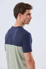 Remera de algodón y poliéster de corte clásico, con diseño en bloques de color negro en la parte superior y gris melange en la inferior. Presenta cuello redondo, mangas cortas y un pequeño estampado tipográfico en el pecho.