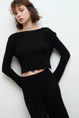 Blusa corta de punto color negro, con cuello redondo y mangas largas.