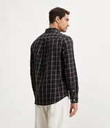 Camisa de hombre de manga larga, confeccionada en franela ligera con estampado cuadrillé en tonos oscuros y líneas finas blancas y naranjas. Cuenta con cuello clásico y abotonado frontal.