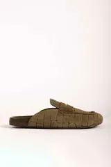 Zueco tipo mocasín destalonado en color verde oliva, con textura grabada efecto cocodrilo y acabado en gamuza.