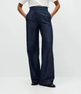 Pantalón de jean corte wide leg en color azul oscuro, con cintura alta, cierre frontal con botón y cremallera, y cinturón de lazo del mismo tejido.