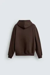 Sudadera tipo hoodie de corte relajado, confeccionada en tejido de algodón con interior cepillado. Presenta capucha con cordones ajustables, bolsillo frontal tipo canguro y terminaciones en rib en puños y ruedo.