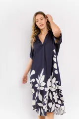 Vestido midi azul marino con estampado de hojas blancas, corte holgado, cuello en V y mangas cortas con dobladillo.