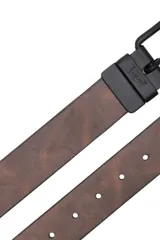 Cinturón reversible de cuero sintético en color marrón con efecto desgastado, cuenta con hebilla metálica en color negro mate y pasador con logo de la marca grabado.