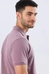 Remera polo de piqué de algodón color azul, de manga corta, con cuello camisero, cierre frontal de dos botones y pequeño logo bordado en el pecho.