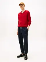 Sweater de punto rojo con cuello en V, manga larga, puños y bajo acanalados, y pequeño logo bordado en el pecho.