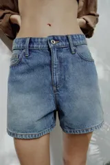 Shorts de denim de tiro medio, corte mom fit, con cinco bolsillos y cierre frontal con cremallera y botón, en color azul lavado.