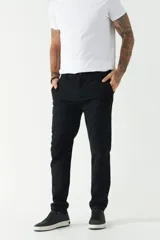 Pantalón chino color beige, de corte slim, con bolsillos laterales y traseros. Se ajusta a la cintura con cinturón de cuero marrón.