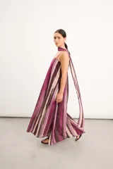 Vestido largo con diseño estampado a rayas verticales en tonos fucsia, marrón y beige, tirantes finos regulables y un lazo largo integrado para el cuello.