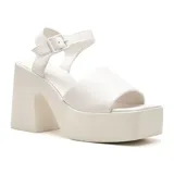 Sandalias blancas de cuero sintético con plataforma y taco ancho. Tira ancha sobre los dedos y pulsera con hebilla al tobillo.