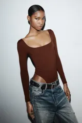 Body de manga larga con escote cuadrado, confeccionado en tejido elástico con cierre inferior mediante botones a presión.