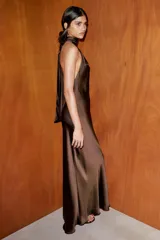 Vestido largo de satén color marrón, con cuello halter y espalda descubierta con cierre de cremallera y lazada.